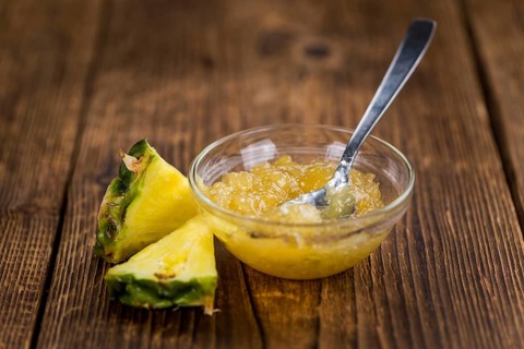 Pineapple Jam as high detailed close-up shot on a vintage wooden table, selective focus