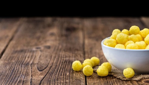 Cheese Balls on rustic wooden background (close-up shot)