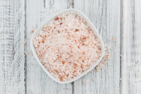 Himalayan Salt as high detailed close-up shot on a vintage wooden table (selective focus)