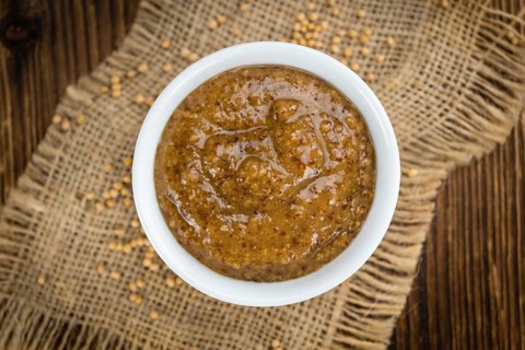 Homemade Sweet Mustard on an wooden table (selective focus) as detailed close-up shot