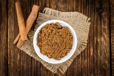 Cinnamon Powder as high detailed close-up shot on a vintage wooden table (selective focus)