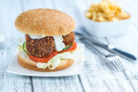 Wooden table with a homemade Falafel Burger (selective focus)