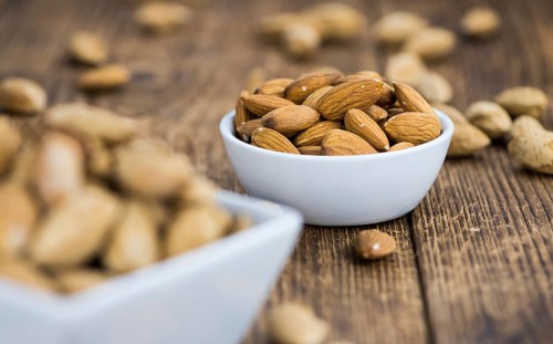 Almonds in shell (roasted and salted) on a vintage background (close-up shot)