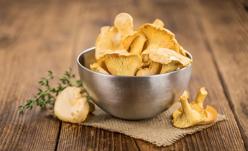 Chanterelles (freshly harvested) on an old wooden table as detailed close-up shot (selective focus)