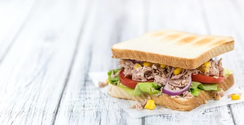 Homemade Tuna Sandwich (selective focus, close-up shot) on vintage wooden background