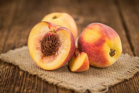 Peaches on a vintage background as detailed close-up shot, selective focus