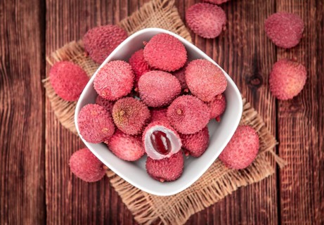 Litchis on rustic wooden background (close-up shot)