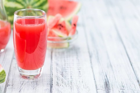 Homemade Watermelon Smoothie on an wooden table (selective focus) as detailed close-up shot