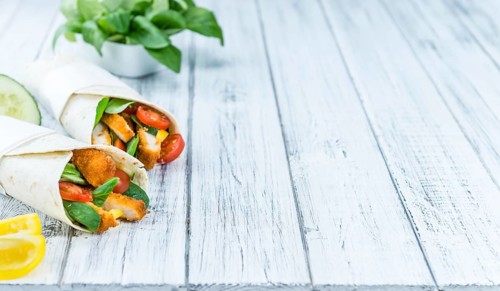 Portion of Chicken Wraps (selective focus) on an old wooden table