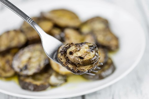 Fresh made Zucchinis (grilled) on an old and rustic wooden table (selective focus, close-up shot)
