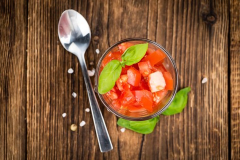 Homemade Diced Tomatoes on an wooden table (selective focus) as detailed close-up shot