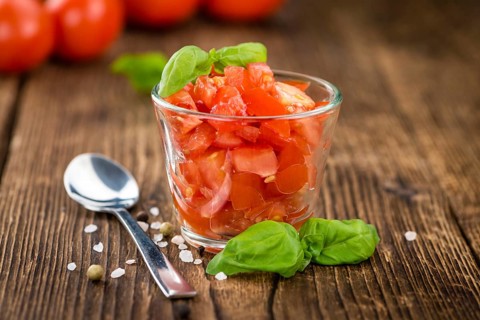 Cutted Tomatoes on an old wooden table as detailed close-up shot (selective focus)