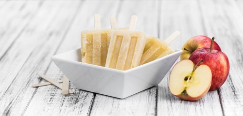 Apple Popsicles on an old wooden table (close-up shot, selective focus)
