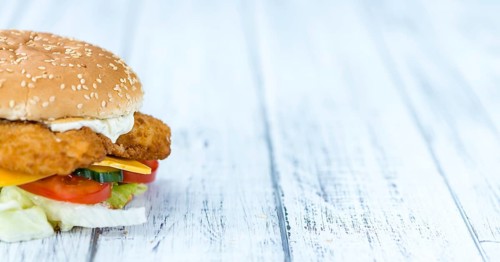 Homemade Fish Burger (close-up shot, selective focus) on a wooden table
