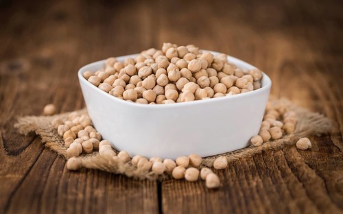 Dried Chickpeas as high detailed close-up shot on a vintage wooden table, selective focus