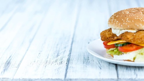 Wooden table with a fresh made Fish Burger (close-up shot, selective focus)