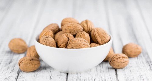 Walnuts on rustic wooden background (close-up shot)