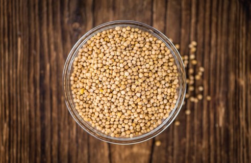 Seeds (Mustard) as high detailed close-up shot on a vintage wooden table (selective focus)