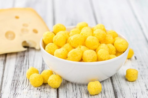 Cheese Balls on an old wooden table as detailed close-up shot (selective focus)