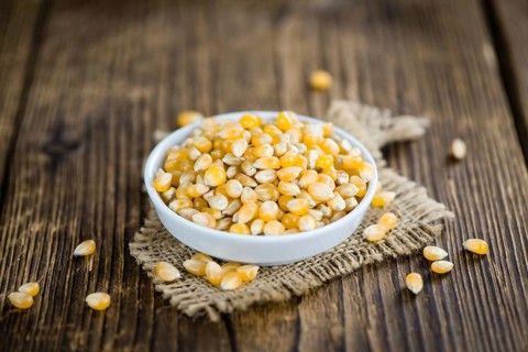 Dried Corn (detailed close-up shot, selective focus) on vintage wooden background