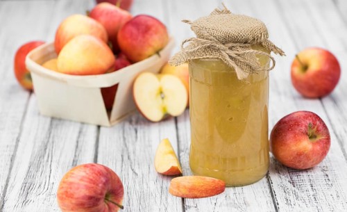 Homemade Applesauce (selective focus, close-up shot) on vintage background with some fresh fruits