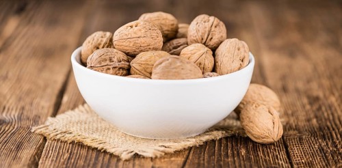 Walnuts on rustic wooden background (close-up shot)