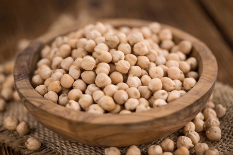 Chickpeas on an old wooden table as detailed close-up shot, selective focus