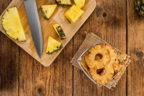Pineapple rings (dried) on rustic wooden background as close-up shot