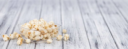 Popcorn as high detailed close-up shot on a vintage wooden table, selective focus