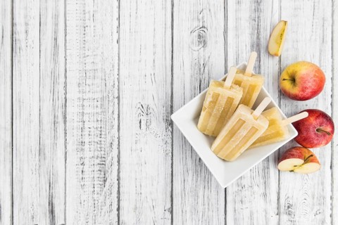 Portion of homemade Apple Popsicles (selective focus, close-up shot) on a vintage background