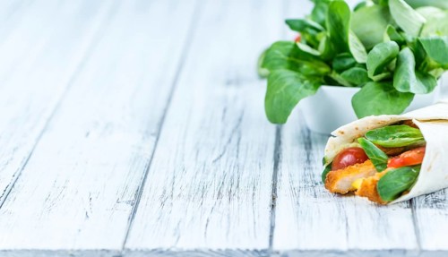 Chicken Wraps on a wooden table as detailed close-up shot (selective focus)