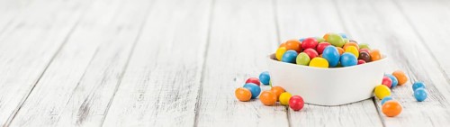 Cocolate coated Peanuts on an old wooden table as detailed close-up shot (selective focus)