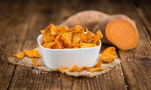 Homemade Sweet Potato Chips on vintage background selective focus, close-up shot