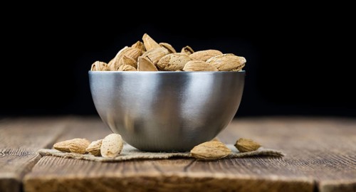 Roasted and salted Almonds (with shell) on a vintage background (close-up shot)