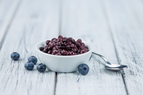 Homemade Preserved Blueberries on an wooden table as detailed close-up shot, selective focus