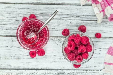 Fresh made Raspberry Jam on an old and rustic wooden table, selective focus, close-up shot