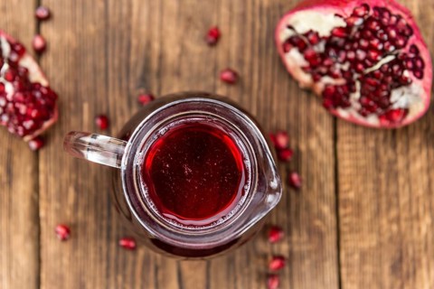 Fresh made Pomegranate juice on a vintage background (close-up shot)