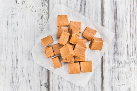 Portion of homemade Caramel on wooden background (selective focus, close-up shot)