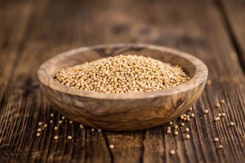 Mustard Seeds on rustic wooden background (close-up shot)