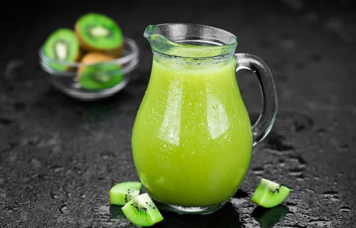 Some fresh homemade Kiwi Smoothies on a slate slab (close-up shot, selective focus)