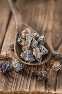 Wooden table with brown Rock Candy (close-up shot, selective focus)