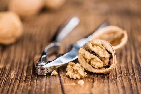 Walnuts on rustic wooden background (close-up shot)