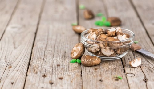 Shiitake mushrooms on an old wooden table as detailed close-up shot, selective focus