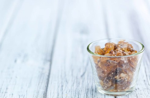 Wooden table with brown Rock Candy (close-up shot, selective focus)