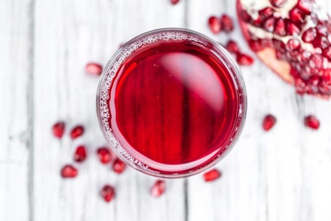 Pomegranate juice on a vintage background as detailed close-up shot (selective focus)