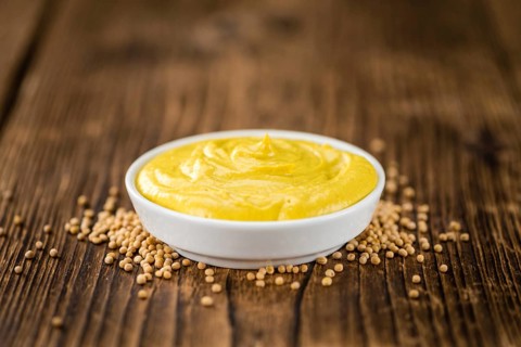 Portion of homemade Mustard on wooden background (selective focus, close-up shot)