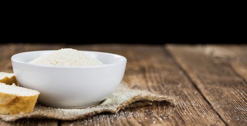 Some Bread Crumbs on a vintage wooden table (selective focus, close-up shot)