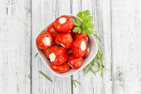 Fresh made Red Pepper (stuffed with cheese) on an old and rustic wooden table (selective focus,