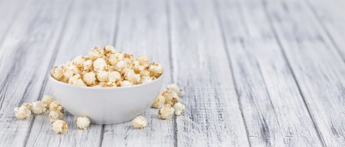 Fresh made Popcorn on an old and rustic wooden table, selective focus, close-up shot