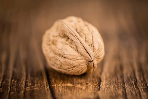Walnuts on an old wooden table as detailed close-up shot (selective focus)